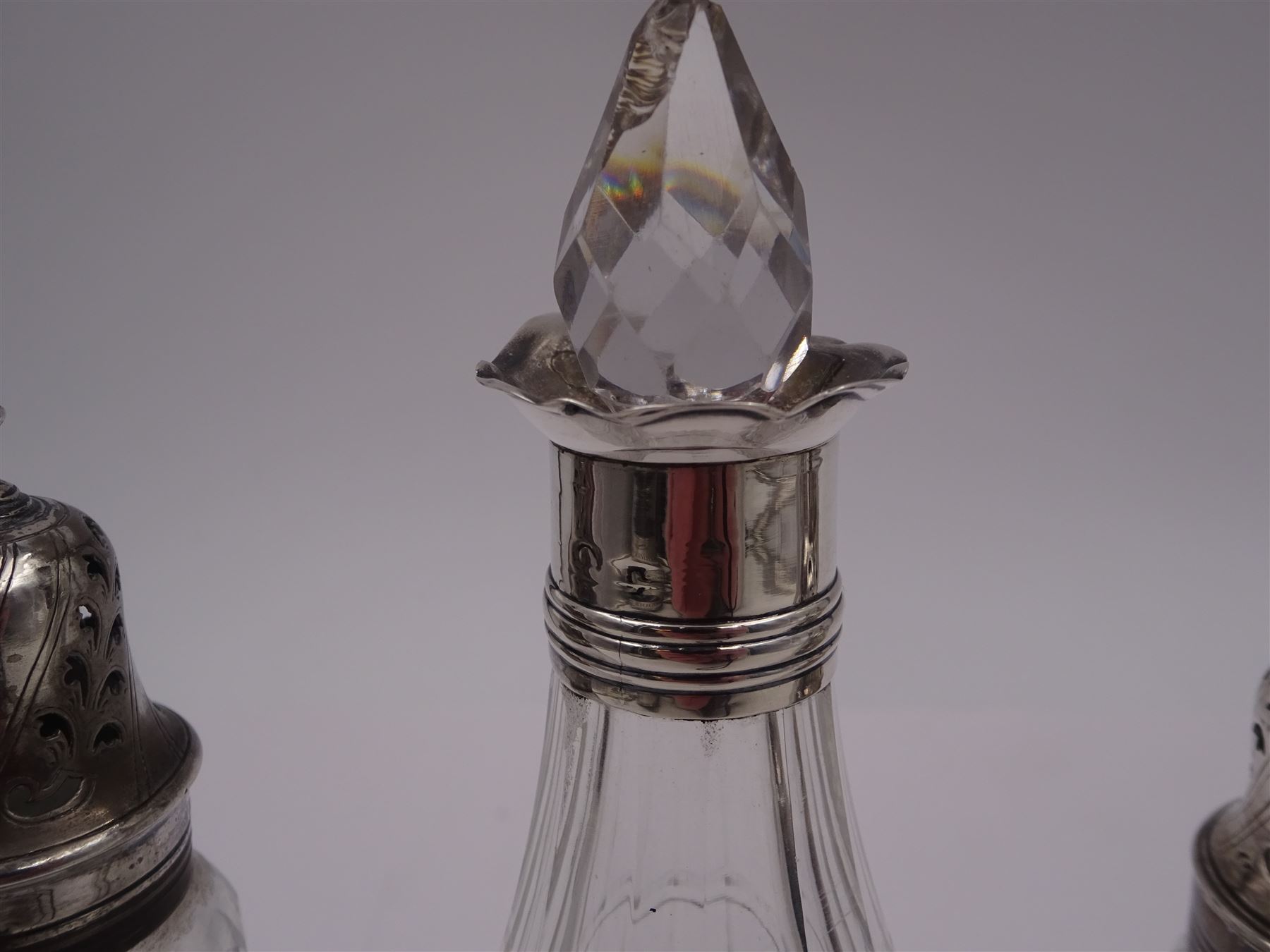 Late 18th century silver cruet stand, of oval form, with pierced sides upon four bun feet, hallmarked to handle Hester Bateman, all other hallmarks indistinct, together with five matched silver mounted cut glass cruet bottles, including some later Victorian examples, hallmarks predominantly indistinct, stand H20cm