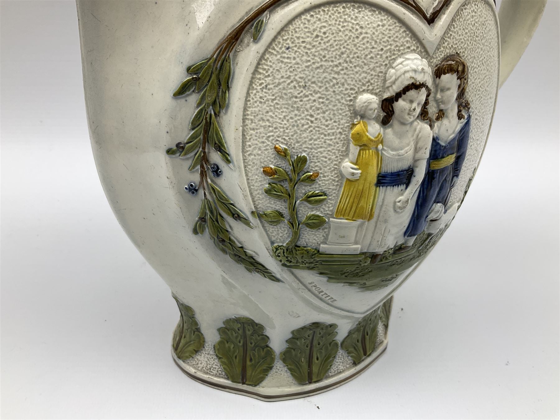 Early 19th century Prattware jug, circa 1800, decorated with two heart shaped panels of children, titled Sportive Innocence and Mischievous Sport, further decorated with acanthus and foliate borders, H22cm