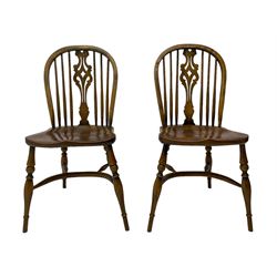 Set of four elm Windsor dining chairs, high hoop and stick back with shaped pierced splat, over shaped saddle seat, raised on ring turned supports joined by crinoline stretcher