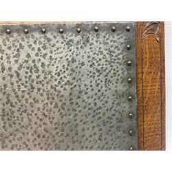 Arts and Crafts oak stand by Arthur Simpson of Kendal, of rectangular form with central hammered pewter panel, surrounded by a border with carved foliate corners, upon two bar supports, bearing label detailed 