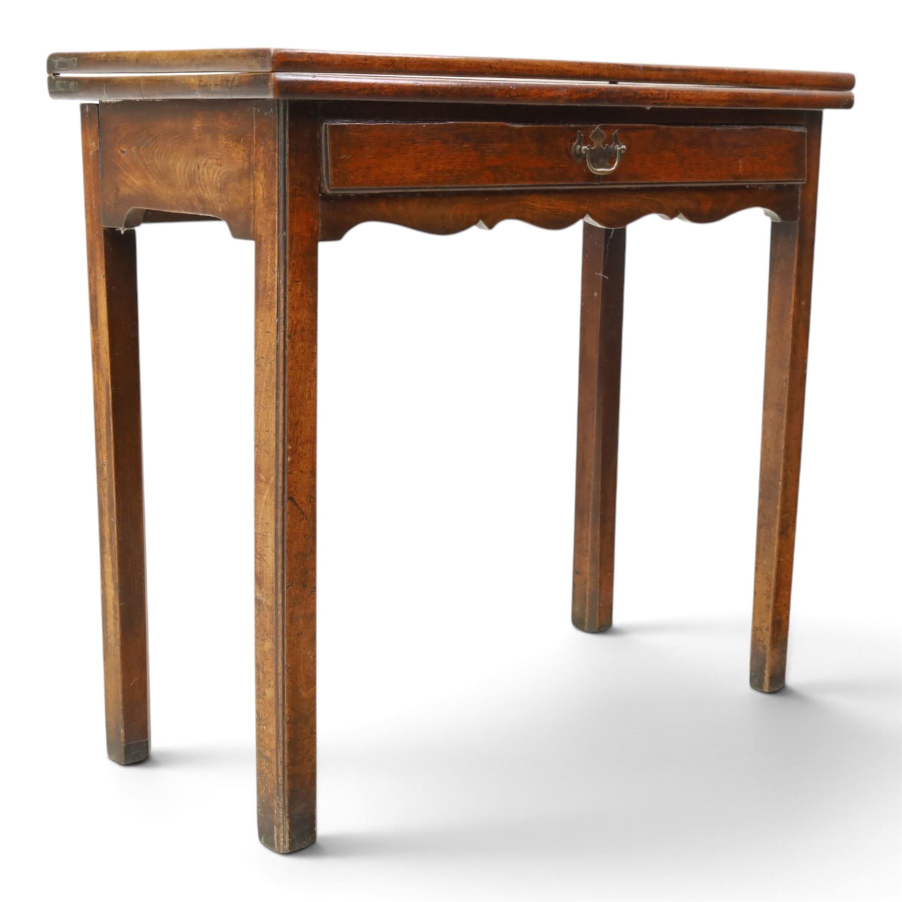 Georgian oak tea table, rectangular fold-over top above single frieze drawer with brass swing handle, shaped apron, gateleg raised on square tapering supports