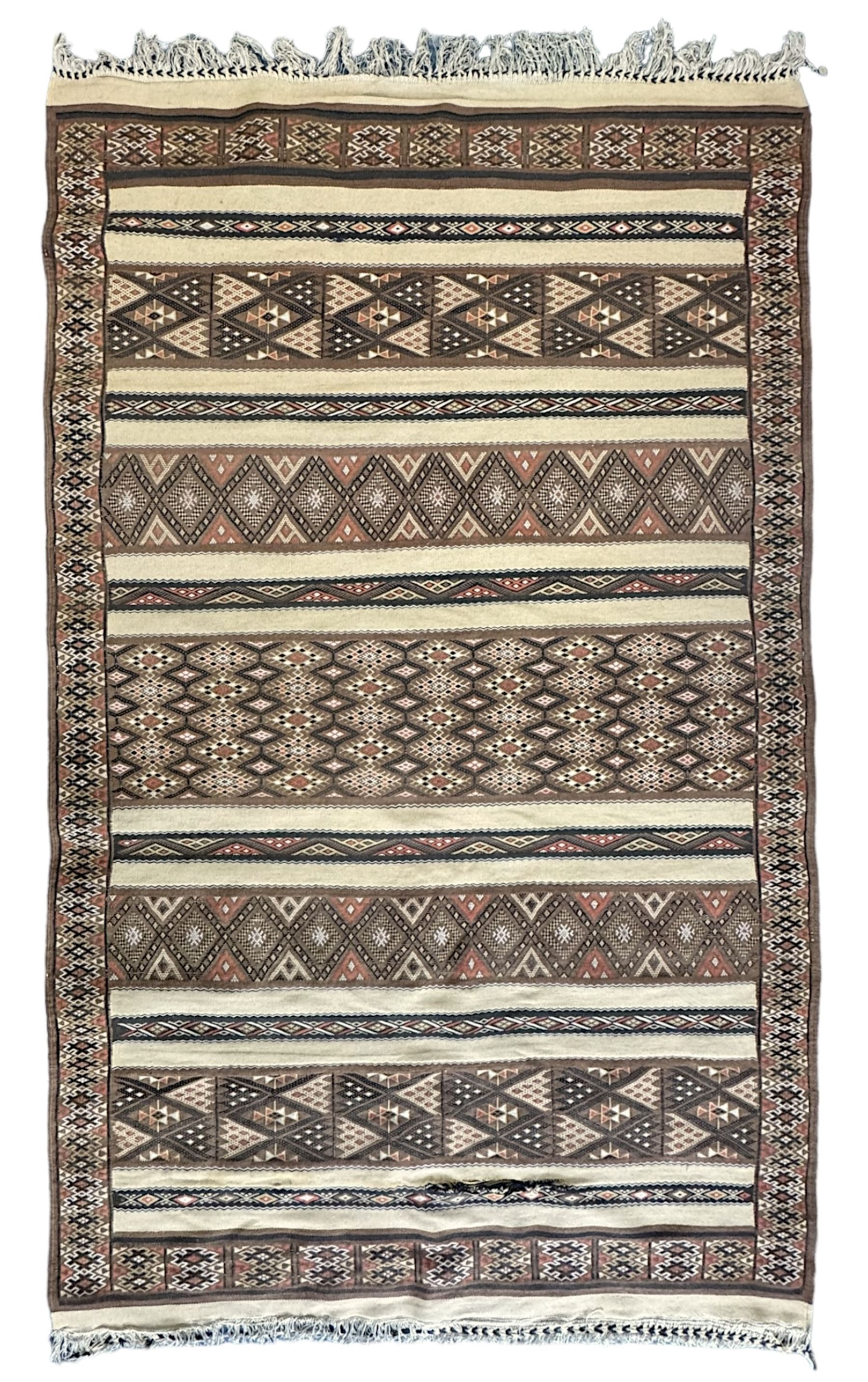 Turkish Kilim ground rug, the field with alternating horizontal bands of geometric patterns, bordered by repeating diamond motifs (145cm x 242cm); Turkish red ground rug, the field with three octagonal medallions (113cm x 172cm) (2)