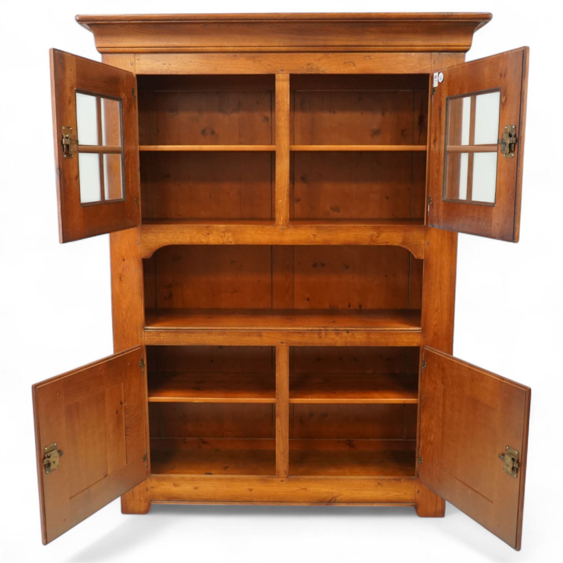 Traditional design solid oak dresser, moulded cornice over twin glazed doors enclosing shelved interior, open centre section, lower base with fielded panel doors opening to shelved cupboards, on plinth base