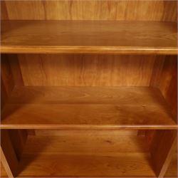 Philip Koomen (1953-) - Craftsman-made modern cherrywood large open
bookcase with a cupboard base, upper section with a
shaped cornice above three sections with two open
shelves, the lower section has three cupboards,
each with two panelled doors enclosing a single
shelf, raised on a plinth base
