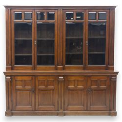 Late 19th century walnut library bookcase, fitted with four display doors with astragal bevelled panes, raised upon a four cupboard base with fielded panel doors