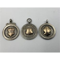 Seven early 20th century silver gold faced cartouche fobs, to include a circular example, with rose gold border and cartouche within an embossed yellow gold border, engraved verso, and a double sided example, all hallmarked with various dates and makers
