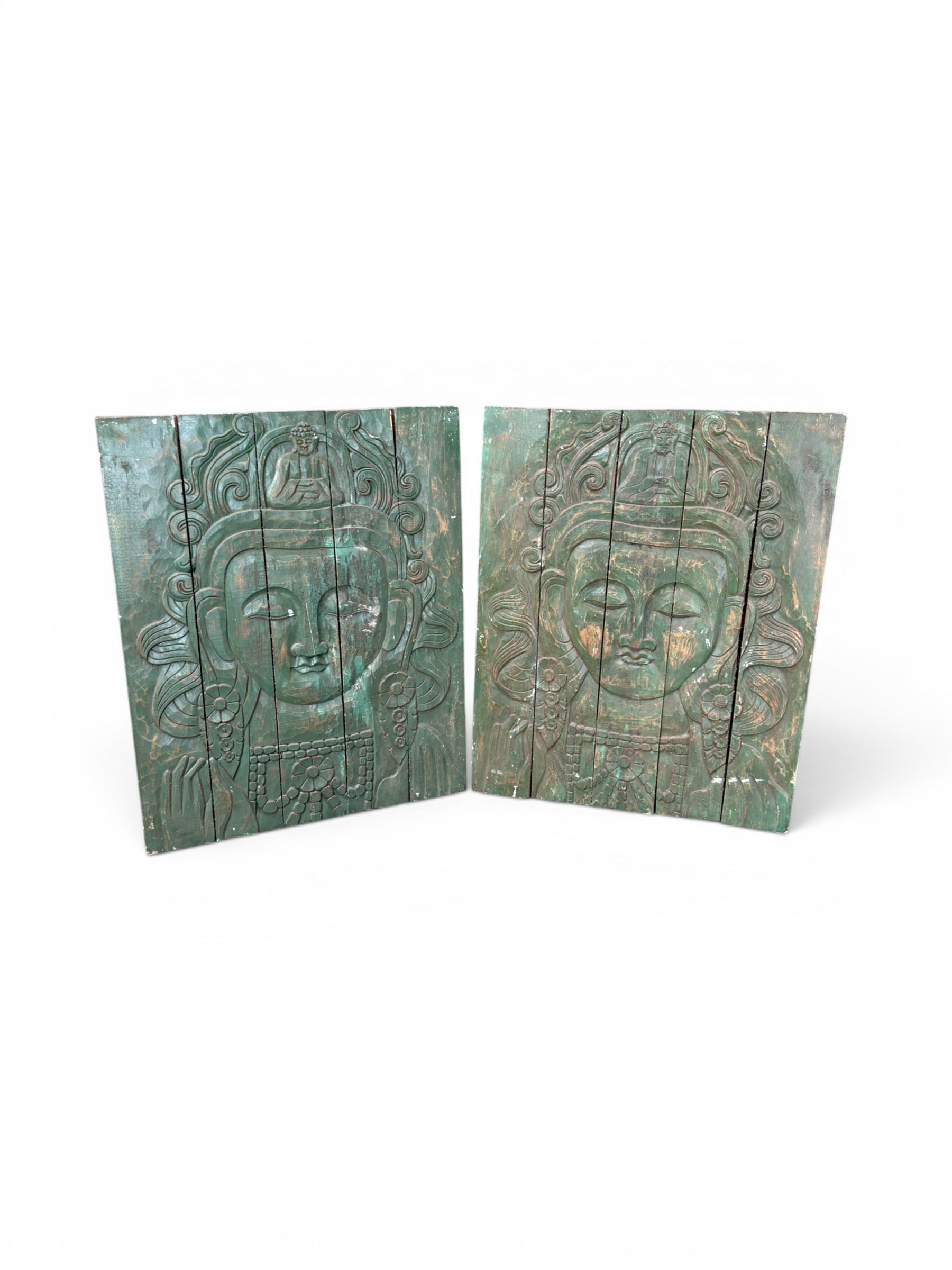 Pair of South East Asian carved wooden panels, depicting Buddha or Deity faces