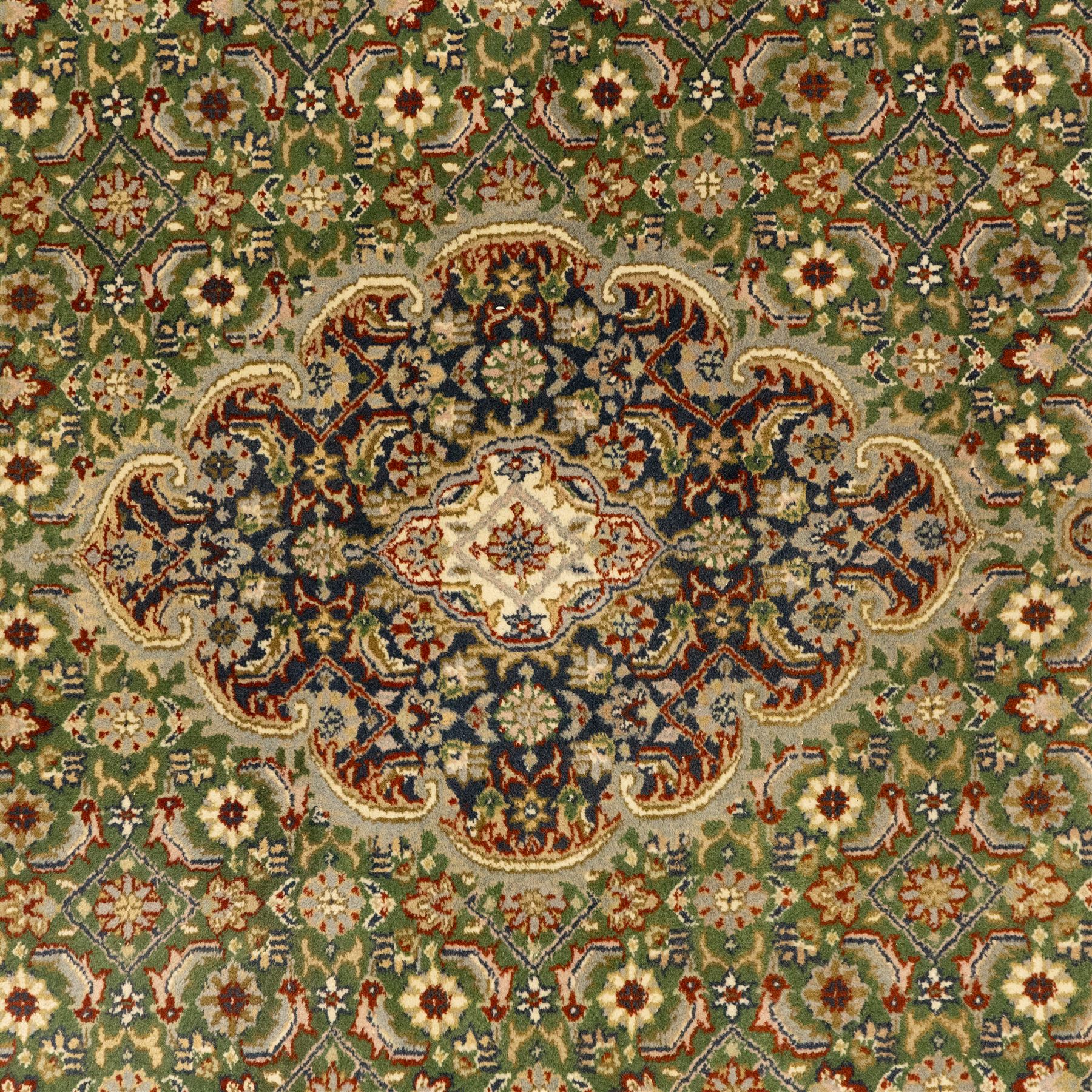 Central Persian Kashan rug, emerald green ground, with a central ivory, indigo, and brick red lobbed medallion with pendant finials, ivory spandrels, framed by multiple floral borders