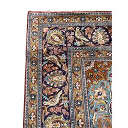 Persian Kashan peach ground rug, central rosette medallion surrounded by trailing branches and flower heads with bird motifs, light blue spandrels with further floral decoration, the main border with repeating palmettes and birds, within guard stripes