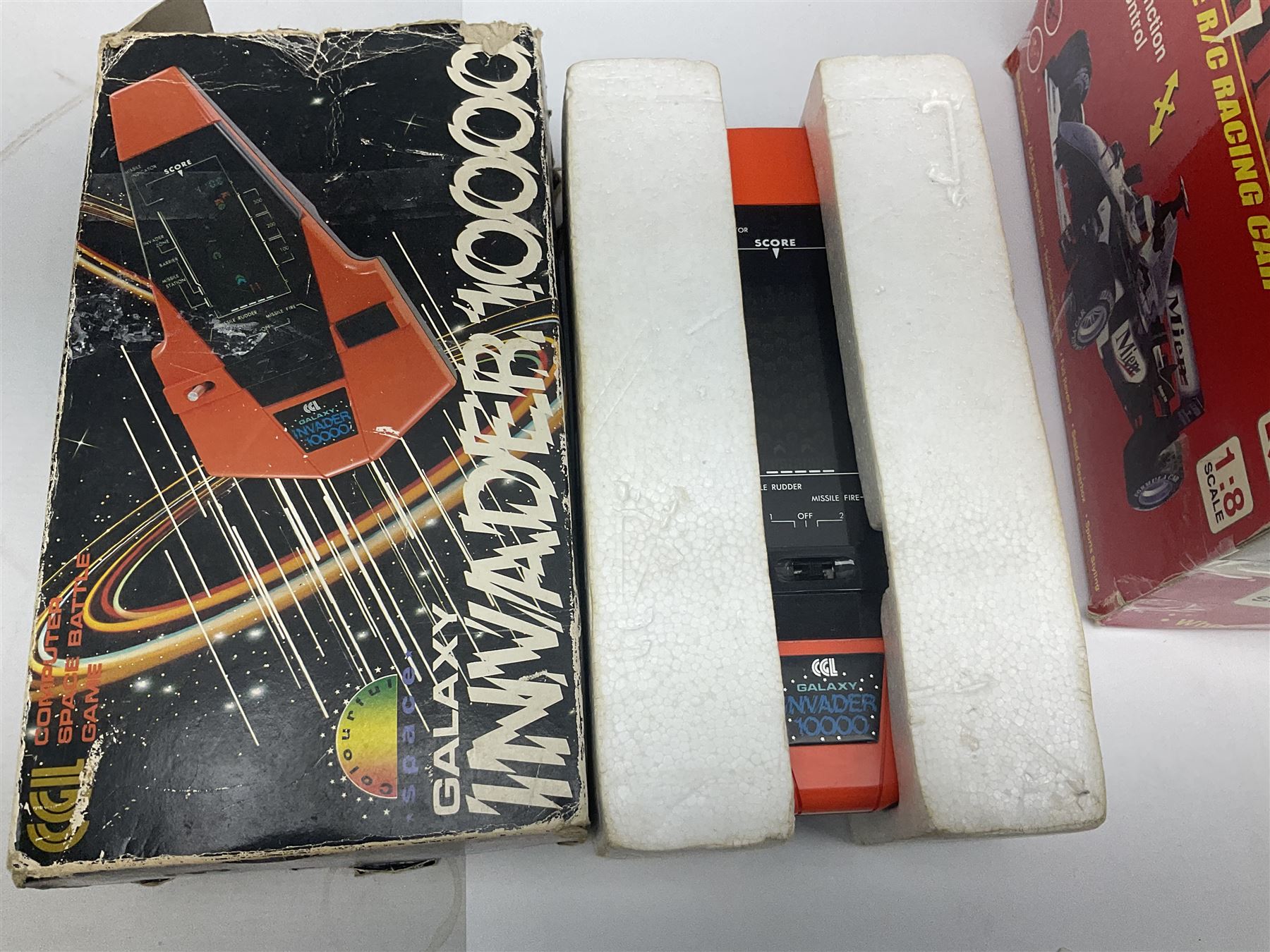 PMS Lightning 1:8 scale remote control racing car; Soma Sonic Man battery operated electronic sounds and light action figure; and CGL Galaxy Invader 10000 computer space battle game; all boxed (3)