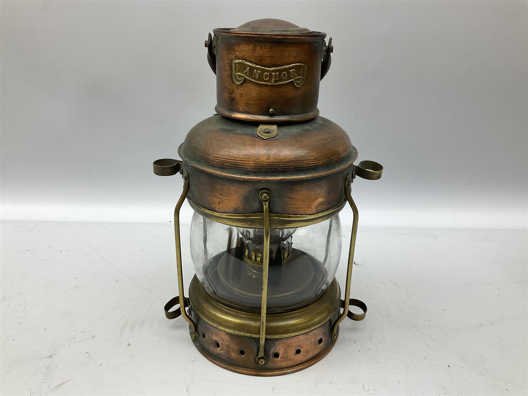 Copper and brass ship’s lamp marked ‘Anchor’, H25cm, Feuer hand storm lantern, Bialaddin Model 315 paraffin lamp and an Anchor lamp (4)