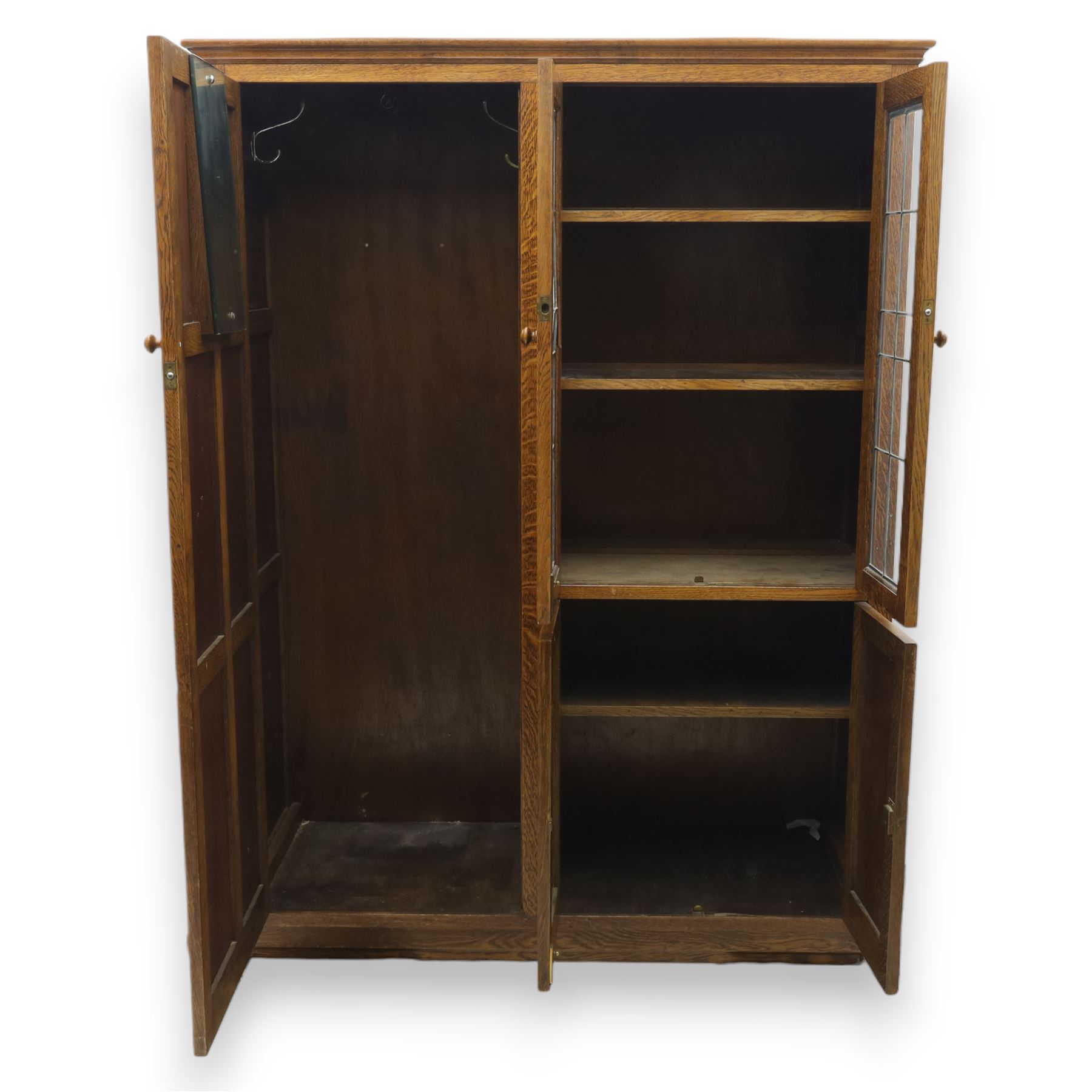 Edwardian oak glazed cabinet, moulded cornice above a panelled front and sides, fitted with lead glazed doors enclosing shelved interior, left side full length cupboard converted to enclose a gun cabinet, on a plain plinth base 