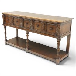 Titchmarsh & Goodwin - Tudor oak dresser base, three drawers flanked by foliate carving and carved wooden knobs, on turned and carved supports, united by a full length undertier