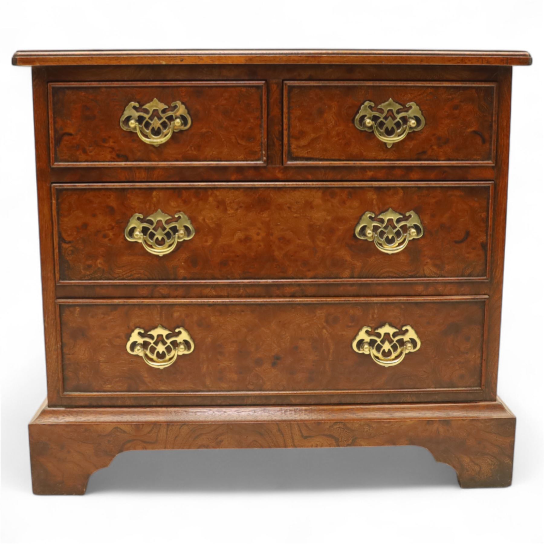 Late 20th century figured walnut miniature chest, the rectangular top with feather banded border over two short and two long drawers, fitted with brass batwing handles, upon moulded plinth base and four bracket feet, H60cm, w67cm, D36cm