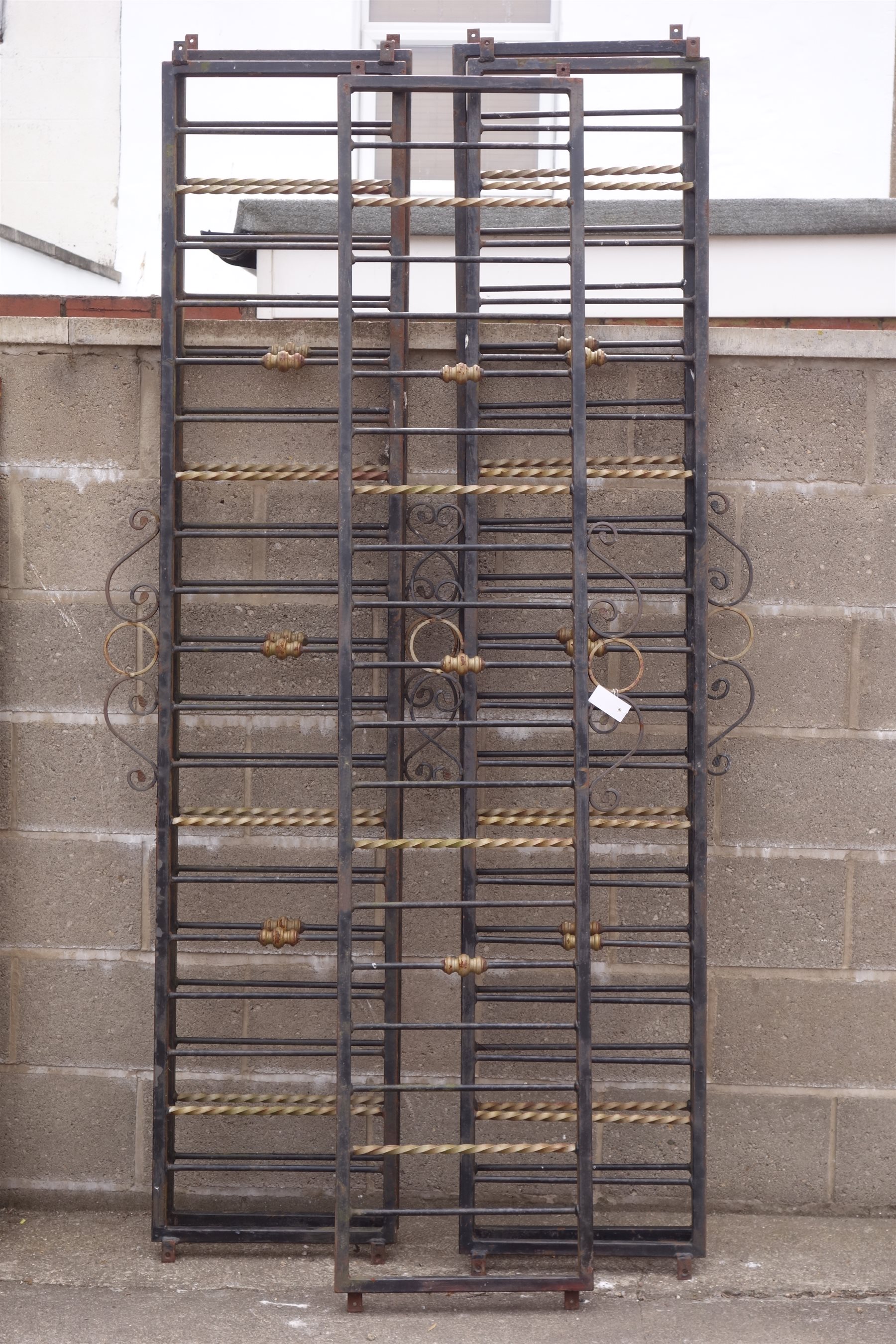 Set five black and gold painted wrought metal wall railings, scrolled