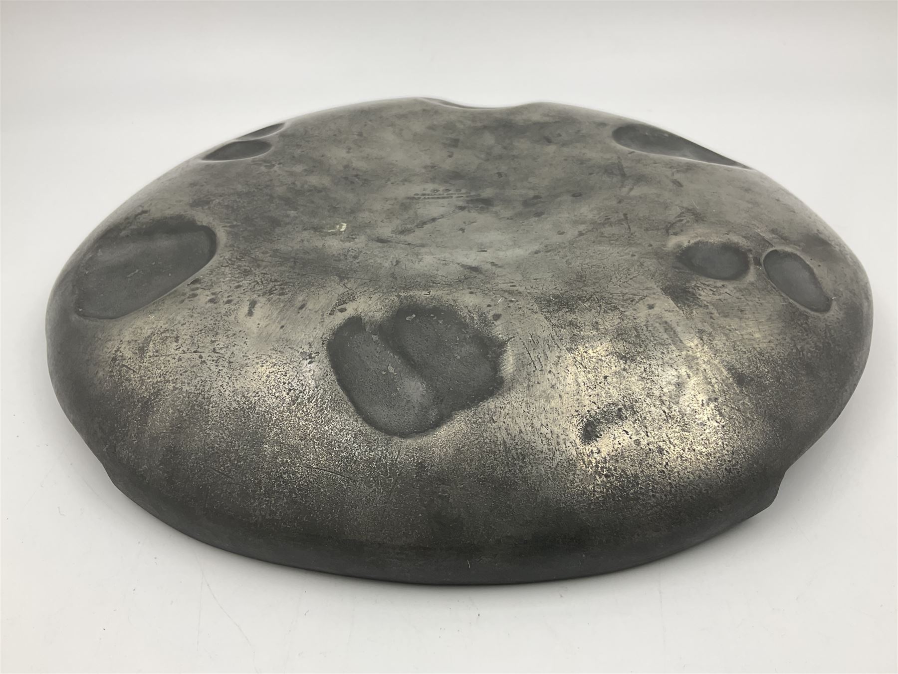 Liberty & Co Tudric pewter Bollelin tray, designed by Archibald Knox, of circular form with shaped edge, cast in relief with foliate tendrils surrounding a green enamel cartouche, impressed beneath Made by Library & Co English Pewter 044, D25.5cm