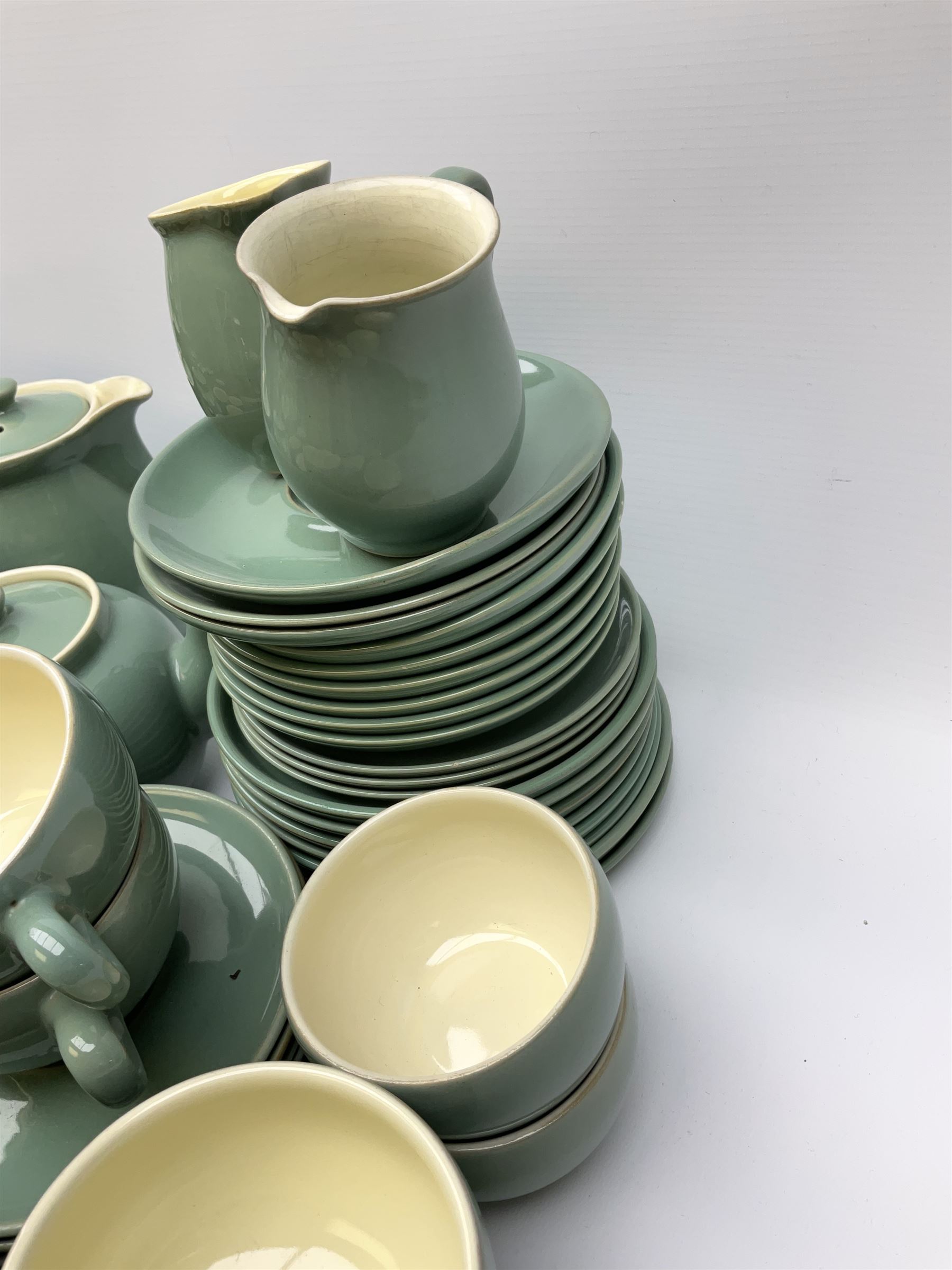 Denby Manor Green pattern tea service, comprising of three teapots, twelve coffee pots of various sizes, four hot water jugs with lids, seven jugs, eleven teacups, four mugs, seventeen saucers, six sugar bowls, two sugar bowls with lids and eleven side plates.  