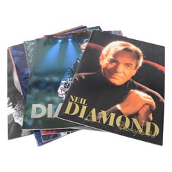 Neil Diamond tour memorabilia, including five t-shirts, cap, programmes, calendar and biography, together with a Neil Diamond In Concert poster, framed
