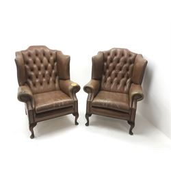 Pair Queen Anne style wingback armchairs upholstered in a deep buttoned studded tan leather, cabriole legs