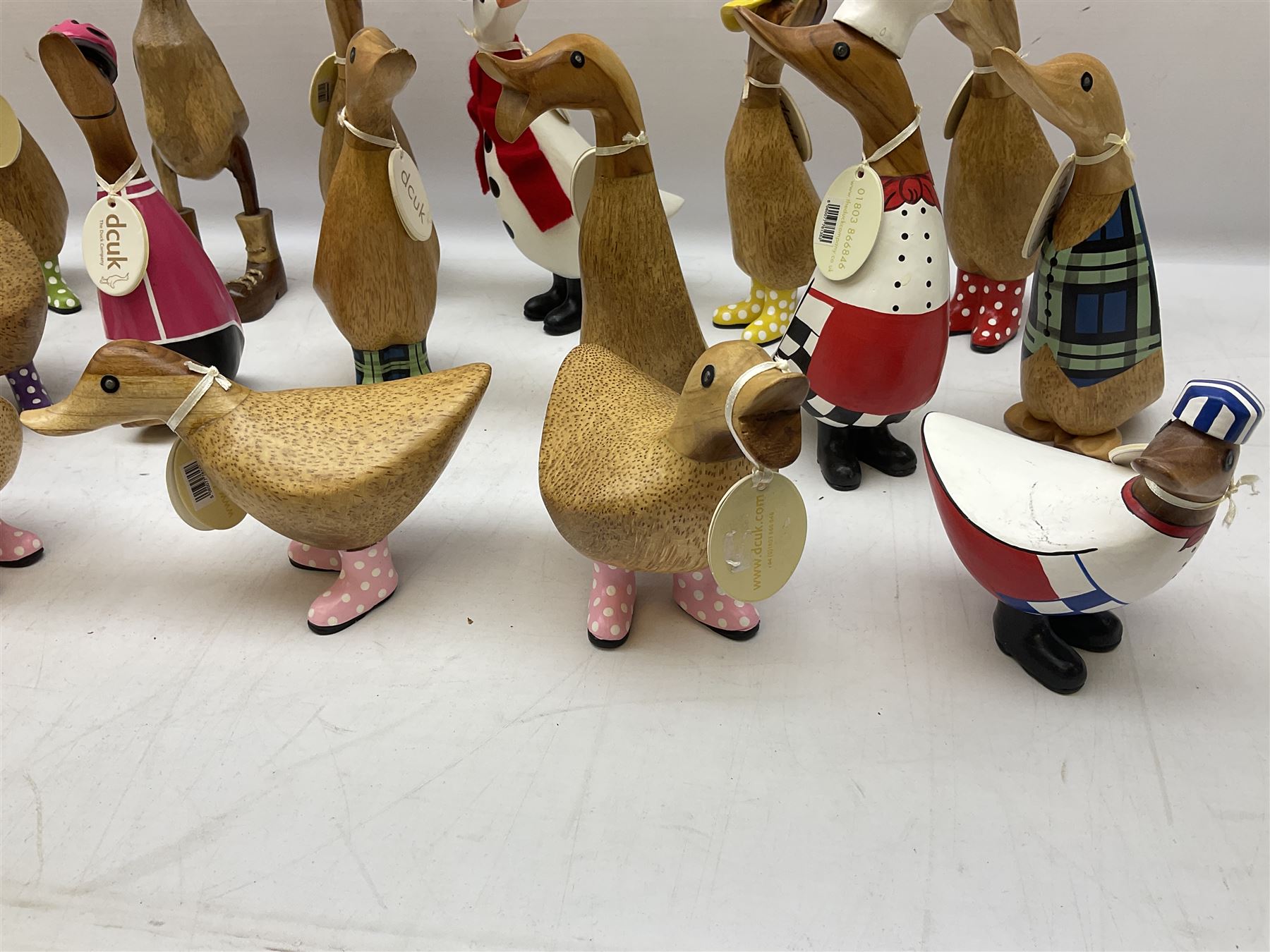 Quantity of the Duck Company UK DCUK carved bamboo root ducks, modelled wearing rain hats and rain boots etc, together with other similar carved wood ducks, tallest H26cm
