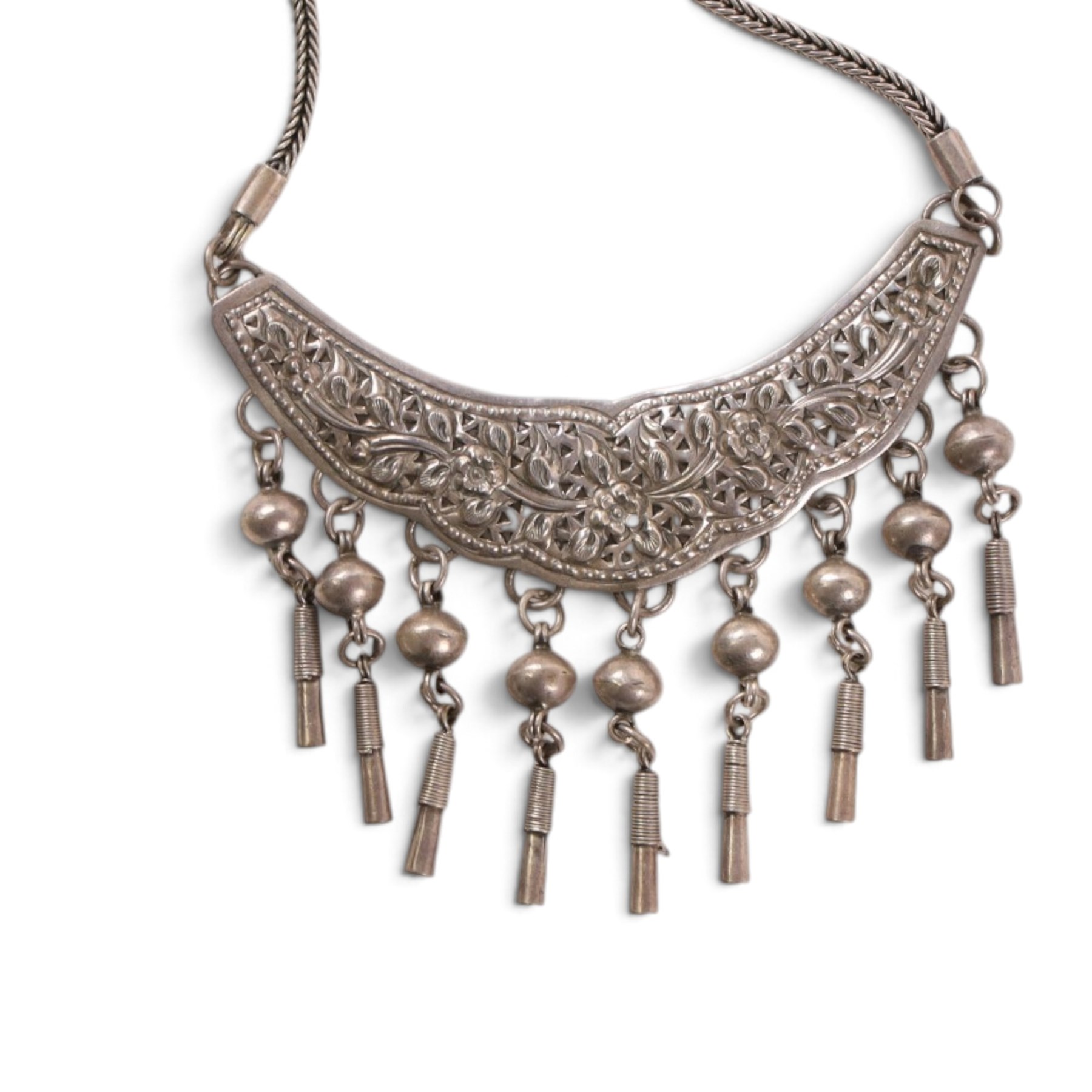 Collection of Middle Eastern jewellery, including silver necklace with a crescent  shaped pendent with beadwork and barrel tasselled ends, nickel silver wedding necklace with filigree decoration, coin bracelet, two bridal wedding caps and two others 
