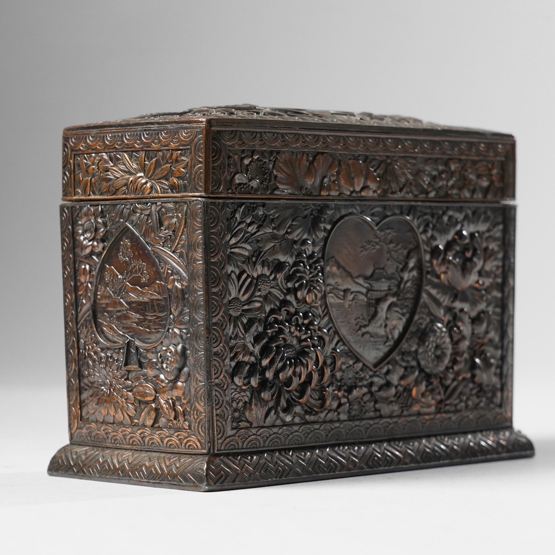 Japanese Meiji period bronze playing card box, decorated with intricate repoussé floral motifs, marked to base