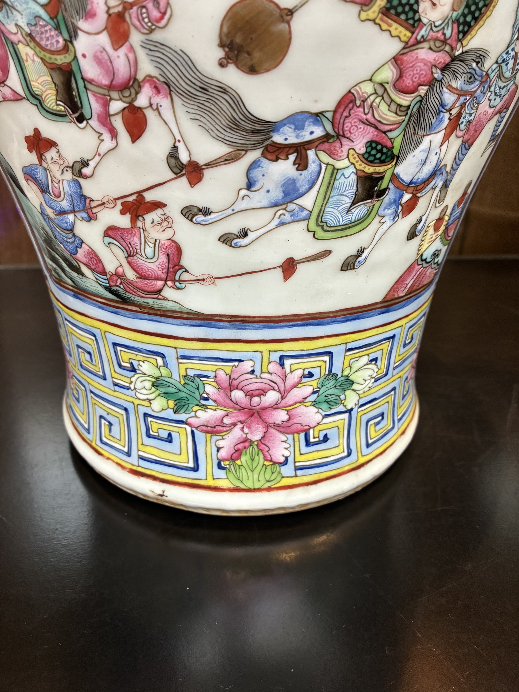 Large pair of 19th century Cantonese famille rose vases, each painted with various courtly scenes, including a display of warriors fighting on horseback before an official and his attendants, double Buddhist lion handles and applied at the shoulders with chilong, the lower band painted with Greek key motif, H58cm (2)