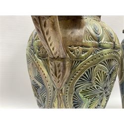 Early 20th century Royal Doulton stoneware vase, decorated with a stylized floral design below a wavy rim, monogrammed B.N, possibly for Bessie Newbery, H28cm, together with an early 20th century glazed jug, heavily carved throughout (2)