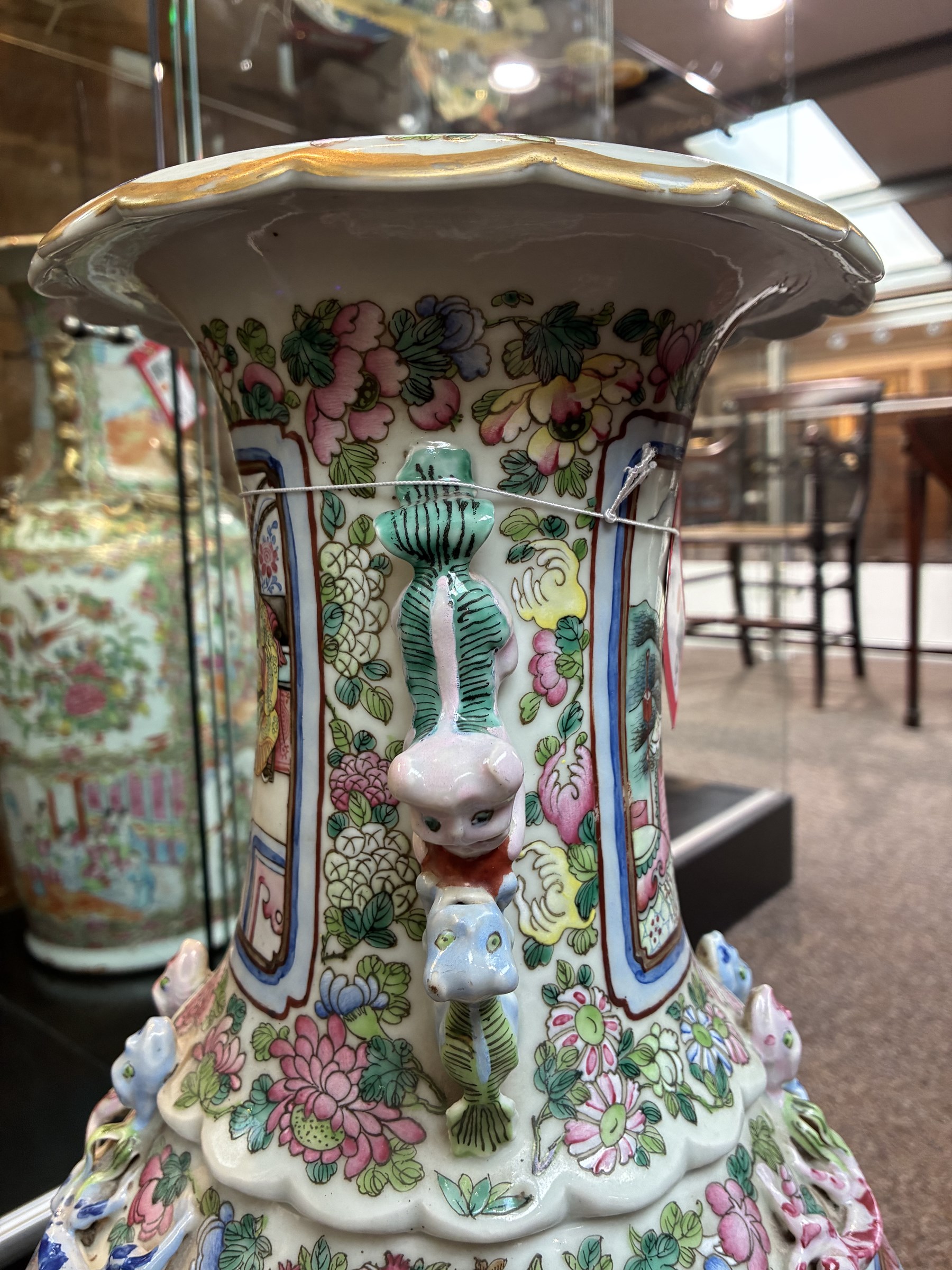 Large pair of 19th century Cantonese famille rose vases, each painted with various courtly scenes, including a display of warriors fighting on horseback before an official and his attendants, double Buddhist lion handles and applied at the shoulders with chilong, the lower band painted with Greek key motif, H58cm (2)