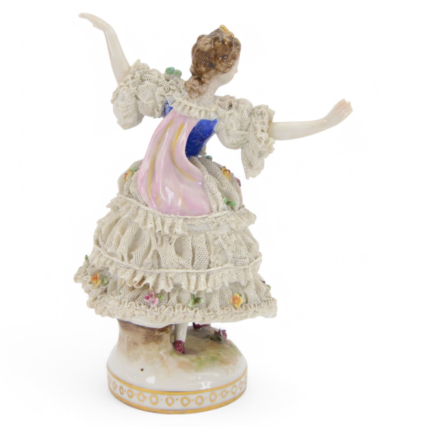Three Continental lace figures, comprising a figure group modelled as two seated female figures reading, with lace trimmed gowns, H19.5cm, the other two examples modelled female figure with arms outstretched, the lace gowns encrusted with flowers, taller example H21cm