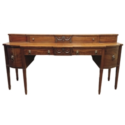  Regency mahogany sideboard, curved and canted break front top, raised back with cupboards enclosed by sliding doors, centre swag and ribbon mounts, two drawers and two cupboards, square tapering legs with peg feet, W224cm, H111cm, D79cm  