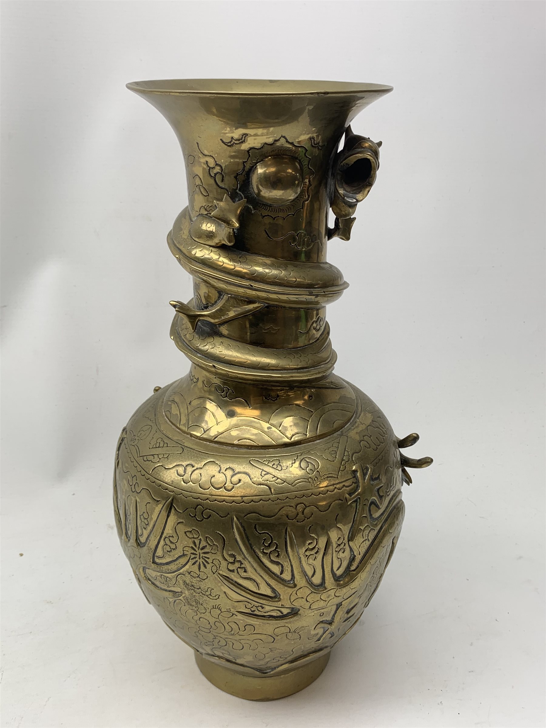 A large Chinese brass vase, of ovoid form with tall neck and flared rim, decorated in relief with dragons chasing a flaming pearl, and further incised with clouds and other detail, the base with relief dragon detail and character mark, H41