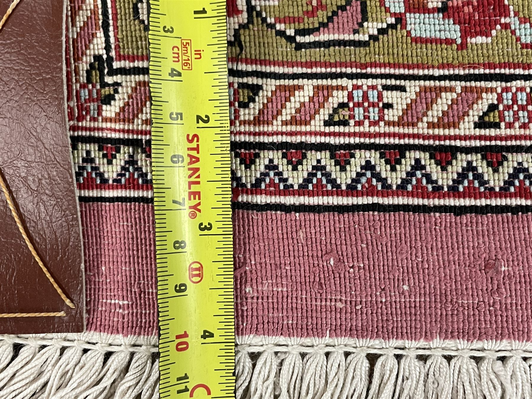 Finely knotted Persian Qom silk rug, overall pink ground with ivory field, the field with central cusped medallion profusely decorated with interlacing foliate and stylised flower heads, multiple band boarder, the main band decorated with a series of stylised motifs and trailing foliage, the outer guard with signature panel 