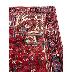 Persian Heriz rug, central stepped star medallion surrounded by stylised plant and flower head motifs, guarded repeating border