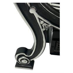 Stained glass and cast iron electric fireplace, arched top with decorative finials, stained glass front panel with floral motifs, flanked by cast iron scrolls, raised on scroll supports