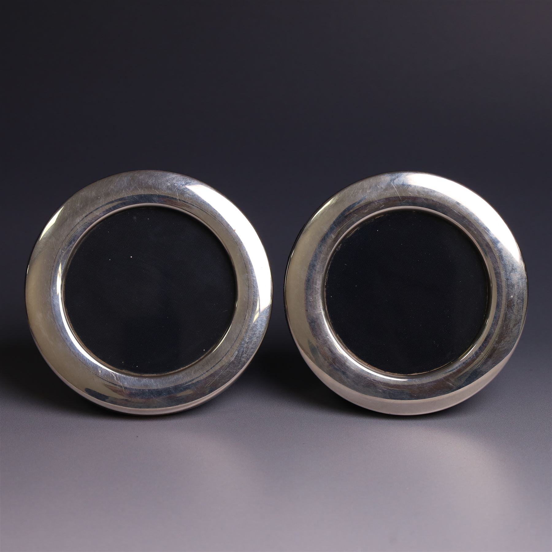 Four late 20th century silver mounted photograph frames, comprising two oval frames and pair of smaller circular frames, all hallmarked Laurence R Watson & Co, Sheffield 1983/4, largest H16.5cm