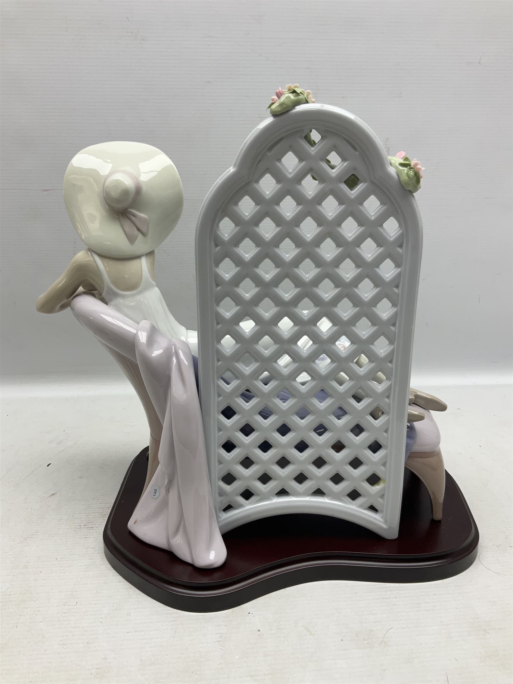 Lladro figure, Garden of Dreams, modelled as a woman reclining in front of trellis of flowers on a mahogany base, limited edition 3129/4000, sculpted by  José Puche, with original box, no 7634, year issued 1994, year retired 1996, H32cm