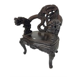 Japanese Meiji period open armchair, the back carved and pierced with dragon and scrolling scaled tails, projecting dragon carved arm terminals on scrolled supports, serpentine seat with decorative band, the apron and supports with scroll and chip-carved decoration

