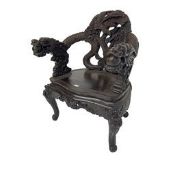 Japanese Meiji period open armchair, the back carved and pierced with dragon and scrolling scaled tails, projecting dragon carved arm terminals on scrolled supports, serpentine seat with decorative band, the apron and supports with scroll and chip-carved decoration
