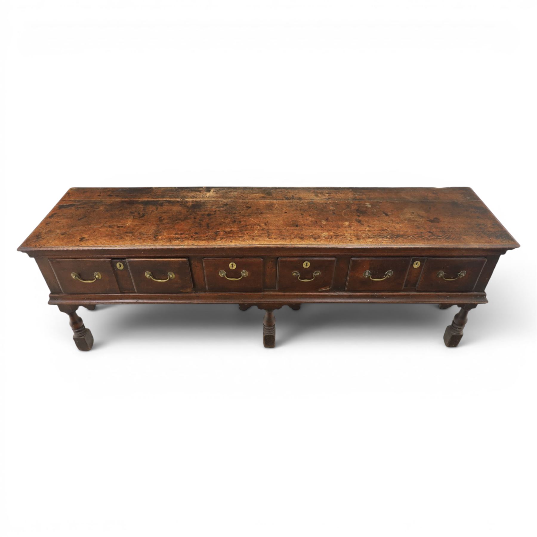 17th century 8’ oak dresser base with moulded front, rectangular top, above four drawers, raised on turned and block support 