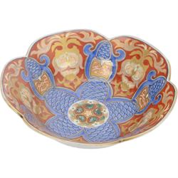 Group of 19th century Japanese Imari porcelain, Meiji period, comprising pair of lobed dishes, decorated stylised reserves and painels in blue and gilt upon a red ground, H6.5cm D21.5cm, a pair of plates of circular lobed form, decorated with a central panel depicting a vase beneath pine branches, and surrounded by panels of flowers and stylised quatrefoil shapes, D21cm, and another similar example painted with a character in underglaze blue to the centre, with character mark beneath, D22cm, each with character marks beneath               