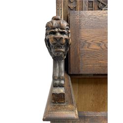 19th century heavily carved oak settle, the moulded upper rail over triangular foliage carved frieze, three Flemish style carved panels depicting tavern scenes, acanthus carved uprights terminating to lion carved arms, hinged box seat, the panelled front carved with lion masks and extending scrolled acanthus leaves, on moulded skirt base