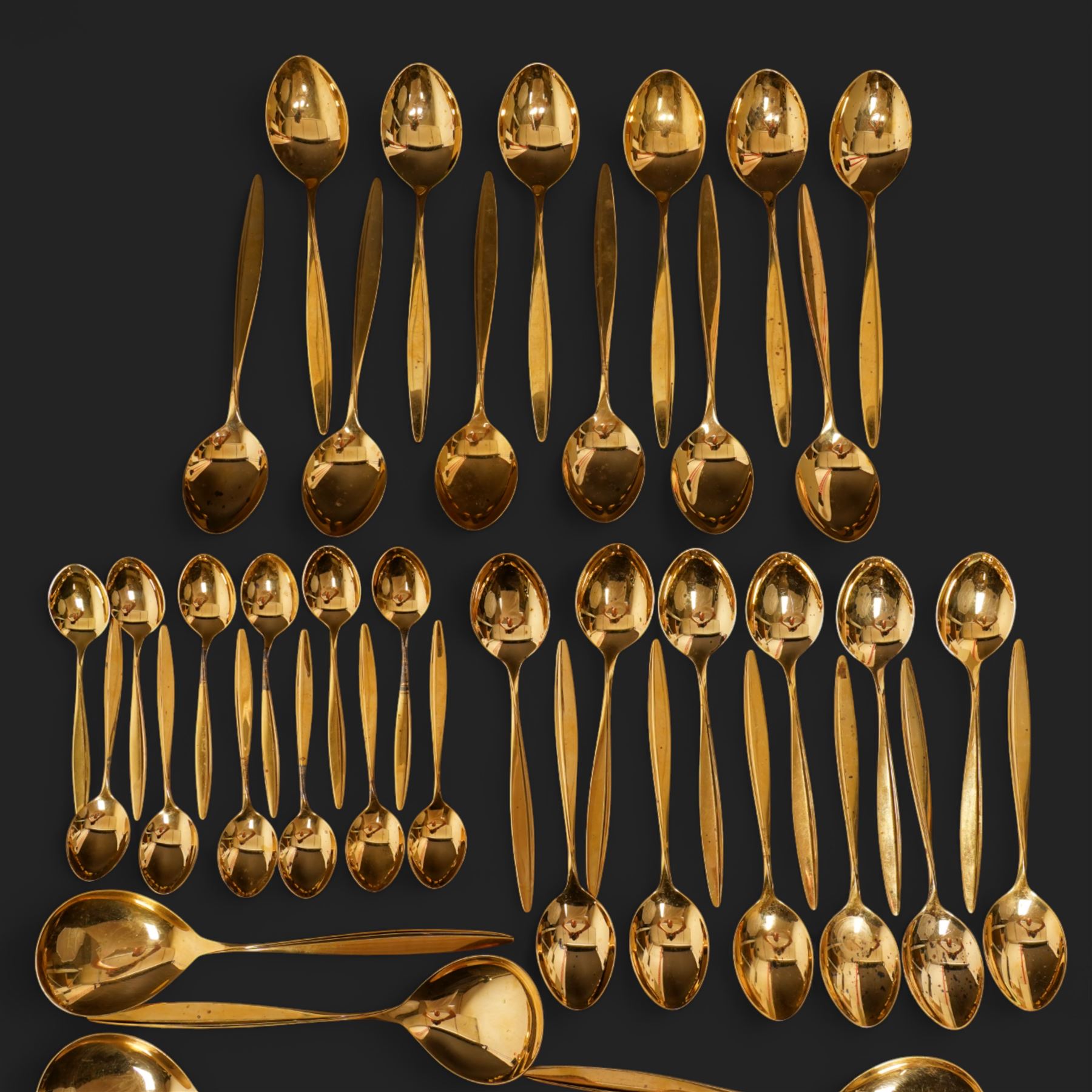Extensive suite of WMF 800 silver gilt cutlery, for twelve covers, comprising twelve table knives and forks, fish knives and forks, dessert forks, table spoons, dessert spoons, teaspoons, eleven dessert forks and six serving spoons, with crescent moon and crown WMF hallmarks