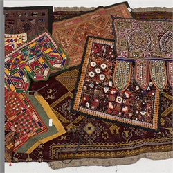 Two Indian Rajasthan tent hangings, worked in coloured threads with suspending fabric panels, large Indian throw worked in cross stitch with Camels and geometric pattern, similar style bags and panels etc