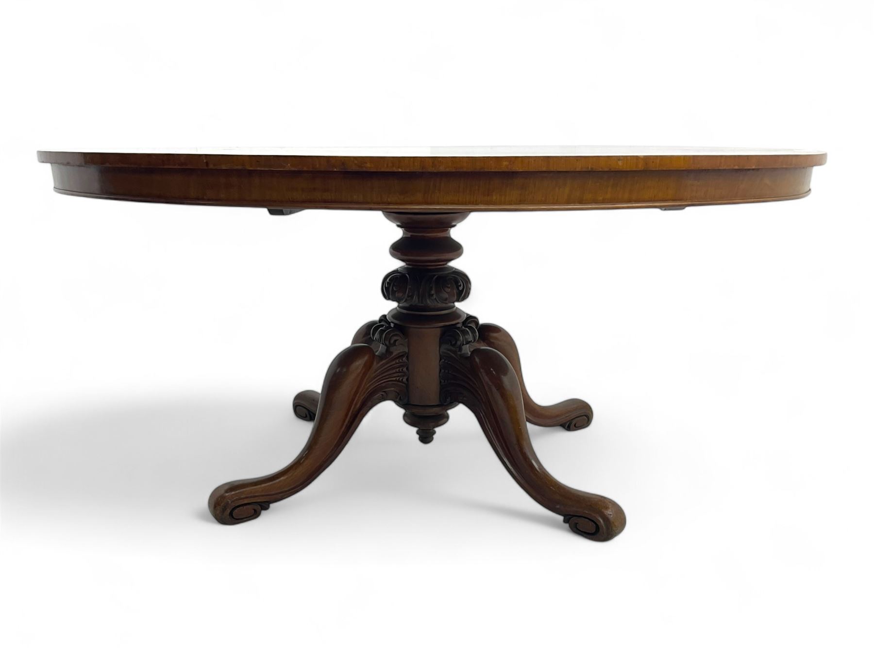 Victorian mahogany breakfast loo table, oval tilt-top on turned pedestal, quatrefoil out-splayed carved supports, scroll carved terminals with brass castors