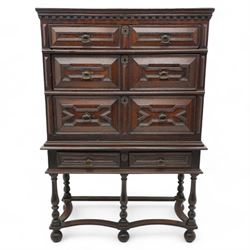 17th century oak chest on stand, moulded cornice over block work frieze, the upper section fitted with three long drawers each decorated with applied geometric mouldings and faceted panels, panelled sides with moulded frame, the stand fitted with two drawers, on five turned supports united by plan flat stretchers, terminating to turned feet