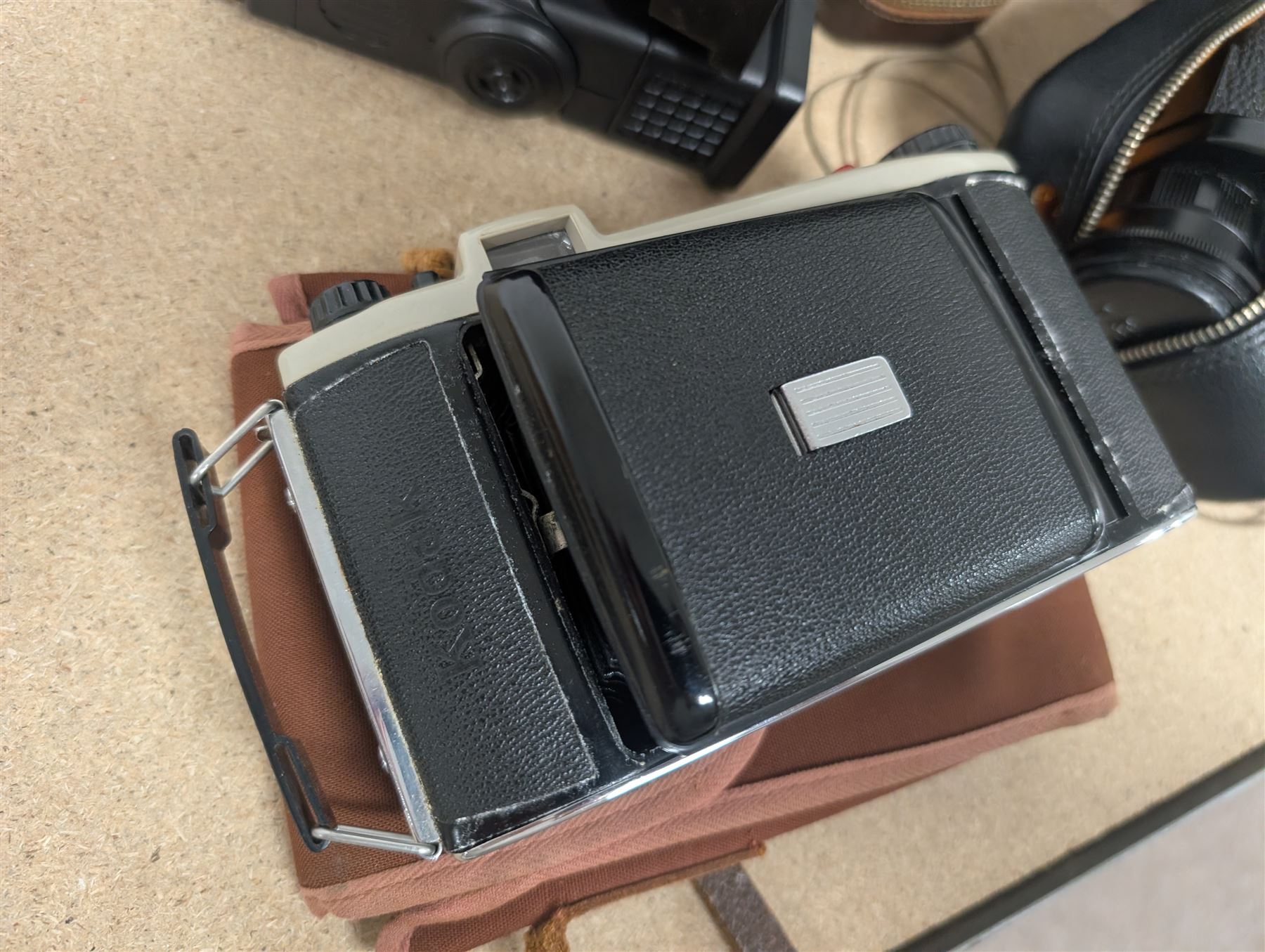 Kodak Dakon II folding camera and a collection of camera lenses and accessories, including Reflex-Nikkor  1:8 f=500mm, NikoN AF Nikkor 70-300mm 1:4-5.6G, Micro TM monocular lens and Teleshot adapter, two cases, Weston exposure meter, two cases etc