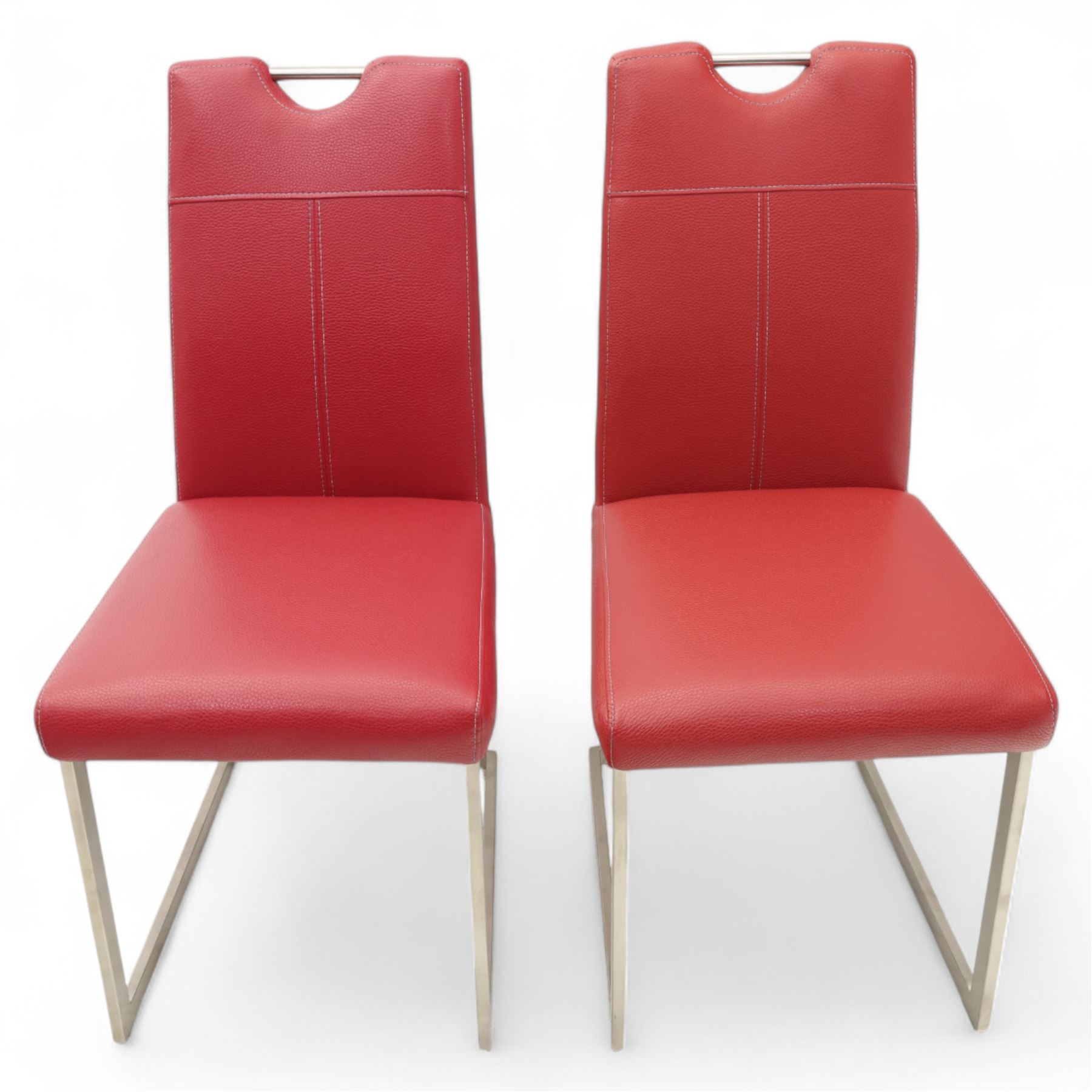 Set of seven contemporary style dining chairs, each with a high padded back and seat upholstered in faux leather on brushed steel sled bases  