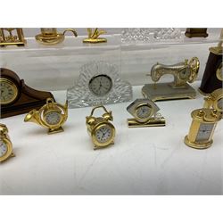 Collection of miniature clocks, predominantly with quartz movements, to include example modelled as an armchair, Edinburgh crystal glass example, clock modelled as a flower, sewing machine etc