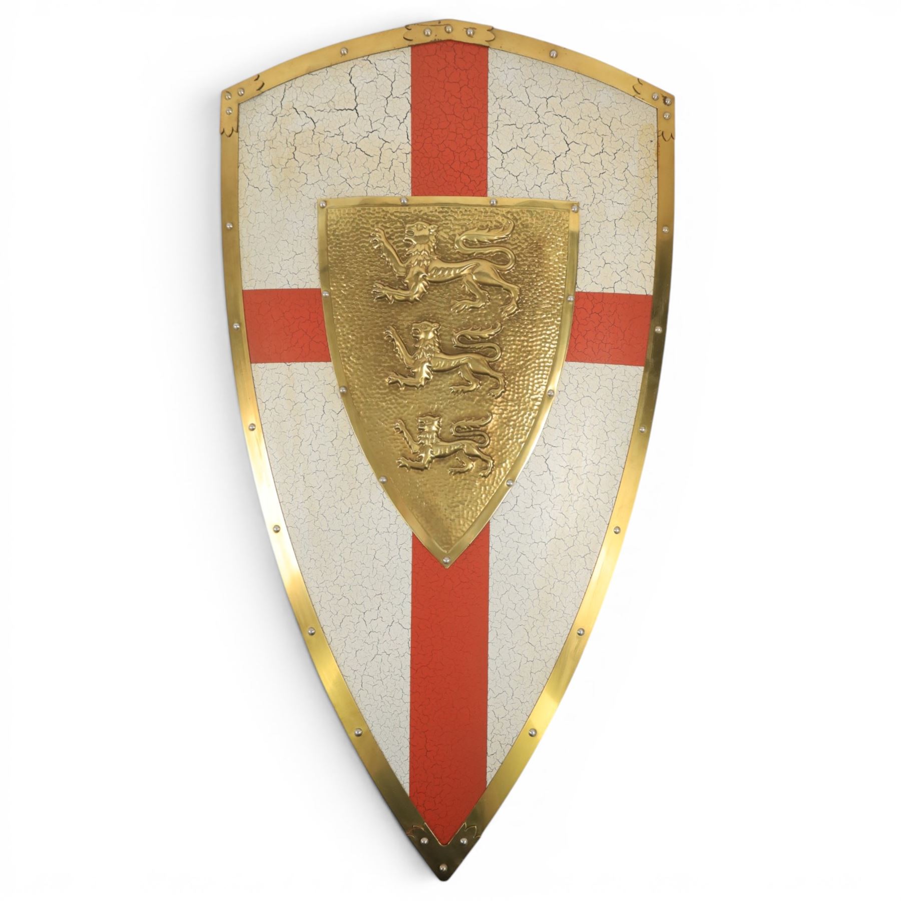 Five wall hangings, modelled as shields, decorated to the centre in relief with three lions 